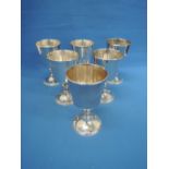 A set of six silver goblets of plain form having shaped stems and clear hallmarks, retailed by