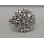 A ladies dress ring having a large diamond cluster, approx 3ct in a raised basket mount on a white