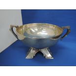 A silver punch bowl of Arts & Crafts style having a moulded angular base with wrap over rim and