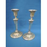 A pair of silver candlesticks of oval form having fan and reeded decoration to tapered columns and