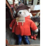 A Paddington Bear wearing traditional dress with card label