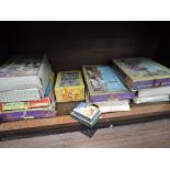 A shelf of vintage jigsaws and card games including; Waddingtons, Good-win etc
