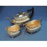 A three piece silver tea set having gadrooned rim, bun feet and ebonised handle and knop,  Sheffield