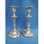 A pair of William IV silver candlesticks of  rococo revival form having floral decoration to