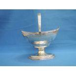 A Georgian silver sugar basket having reeded handle, bright cut decoration and plain cartouche,