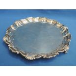 A silver salver having having a pie crust rim with scalloped decoration and ball and claw trefoil