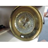 An early 20th century brass circular plaque depicting Lyre player