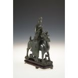 A CHINESE SPINACH JADE GROUP, 19th/20th Century, of female deity riding a stag, the figure seated to