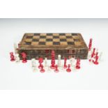 AN ENGLISH CARVED IVORY CHESS SET, one side stained red, the other left natural, contained within