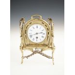 AN UNUSUAL 19TH CENTURY BRASS DESK CLOCK, with a circular enamel dial and drum movement, within a