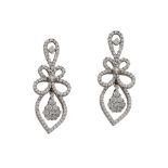 A pair of diamond earrings, each of scrolled openwork design, set throughout with round brilliant-