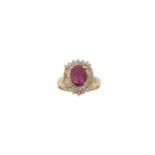 A diamond and ruby ring, composed of an oval mixed-cut ruby to a bagette-cut and round brilliant-cut