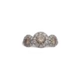 A diamond three-stone ring, composed of three graduated round brilliant-cut fancy coloured diamonds,