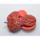 A group of six red cinnabar lacquer buttons, each 2.5cm diameter