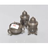 A 1920's pewter three piece condiment set, each piece hammered and raised on three legs.