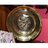 A large brass charger with central embossed armorial, 51cm diameter