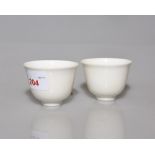 A pair of Chinese egg shell porcelain tea bowls, white glazed and with dragon and flaming pearl