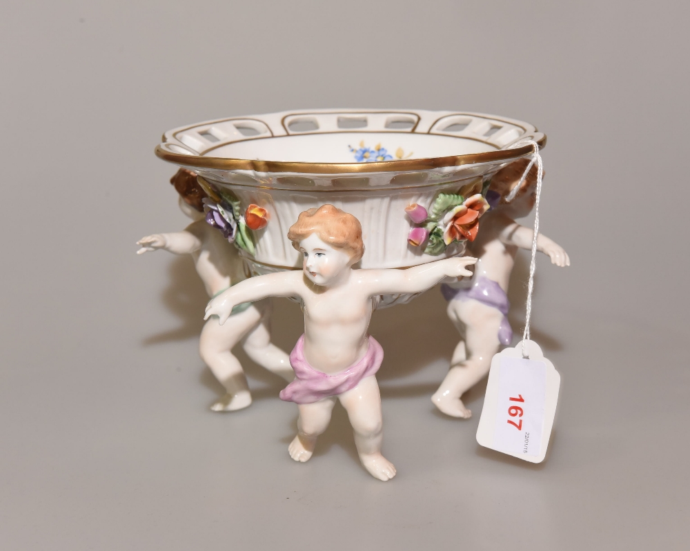 An early 20th century Continental porcelain comport with pierced bowl supported by three cherubs,