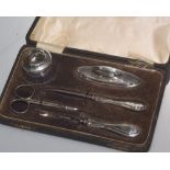 A cased manicure set comprising: silver mounted dressing table jar and buffer; silver handled