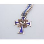 A World War II period bronze 'Der Deutschen Mutter' medal, the white and blue enamel cross on