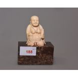 A Chinese ivory figure of buddha on a hard stone stand