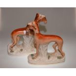 A pair of 19th Century Staffordshire figures of Greyhounds with game, 28cm high