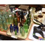 A tray of vintage apothecary bottles inc. green brown and blue glass. Examples inc. E Harper, R