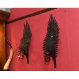 A pair of patinated metal fern-form wall mounted candle sticks