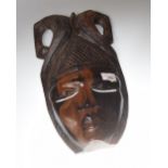 A 20th Century African carved face mask, 40cm high