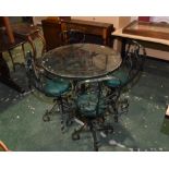 A wrought iron glass topped garden table, tog. with four chairs