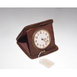 An early 20th century Finnigans eight day travel clock in leather case