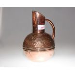 An Arts & Crafts copper water jug, bears brass stamp to base for Henry Loveridge & Co.,