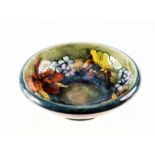 A WILLIAM MOORCROFT FLAMBE ORCHID PATTERN FOOTED BOWL, impressed and painted marks (a/f, hairline