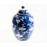 A 19th CENTURY CHINESE BLUE AND WHITE JAR AND COVER, decorated with flowering prunus on a cracked