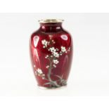 A SMALL JAPANESE RED ENAMEL VASE, of shouldered form, painted with a blossoming tree against a