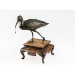 A JAPANESE PATINATED BRONZE MODEL OF A CURLEW, possibly Meiji period, with one foot raised, on a