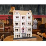 A painted wooden doll's house in the form of five storey town house