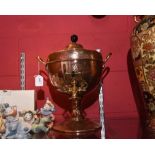 A brass and copper tea urn in the Arts & Crafts taste, with ebonised wooden knop, and stylised