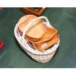 A wicker basket containing tea wares and ceramic dishes