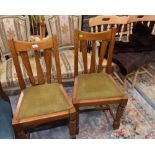 A pair of early 20th century oak dining chairs in the Arts & Crafts taste