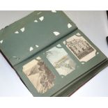 A photograph album containing a quantity of early 20th century black and white and coloured