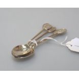 Golf interest: a set of four silver tea spoons, each with an engraved terminal of crossed golf