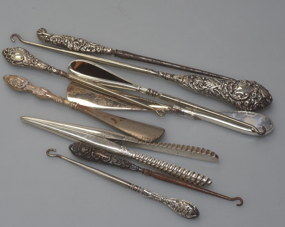 A group of Victorian silver mounted button hooks and glove stretchers (9)