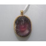 A 19th century intaglio carved amethyst pendant, carved as a female bust, oval, in a gold (unmarked)