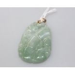 A Chinese gold-mounted green hardstone pendant, the bale unmarked but tested. Length overall 60mm