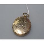 A gold locket, (unmarked) of oval shape engraved with flowers and foliage to both sides,  with