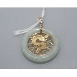 A Chinese 9ct gold mounted green hardstone bi-disc pendant, set to the centre with a pierced