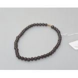 A garnet bead necklace, the uniform single strand on a gilt-metal barrel clasp. Length approx. 40cm