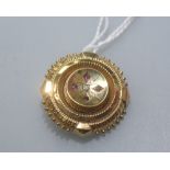 A late Victorian diamond and garnet set "target" brooch with glazed locket reverse. Diameter 30mm