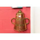 A brass and copper wall mounted urn